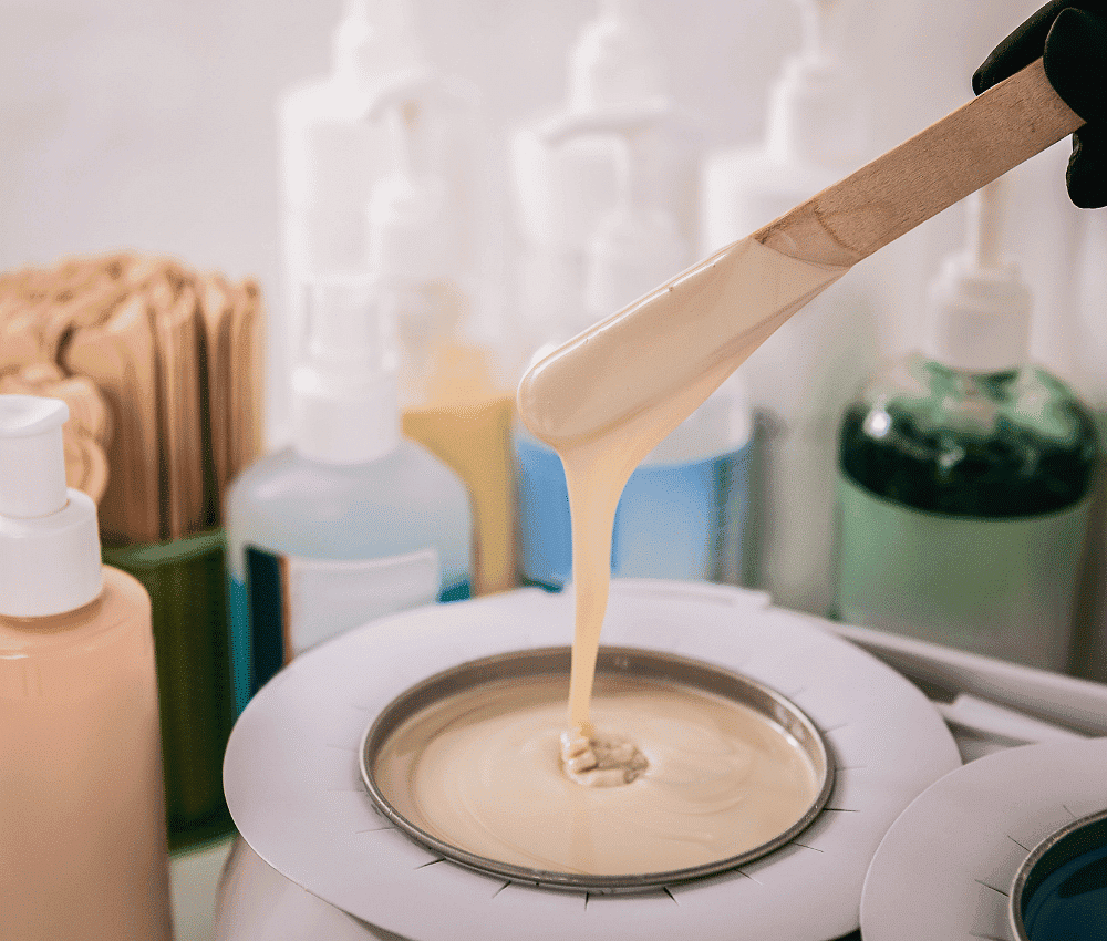 Wax being poured onto a heating device in a beauty salon.