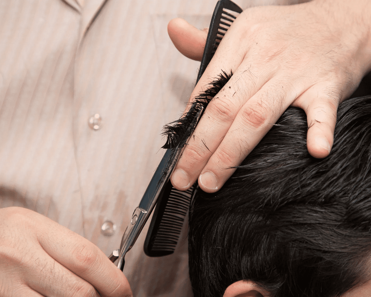 Close-up of a haircut in progress with scissors and comb.